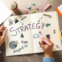 Concept of business strategy on gray table, top view